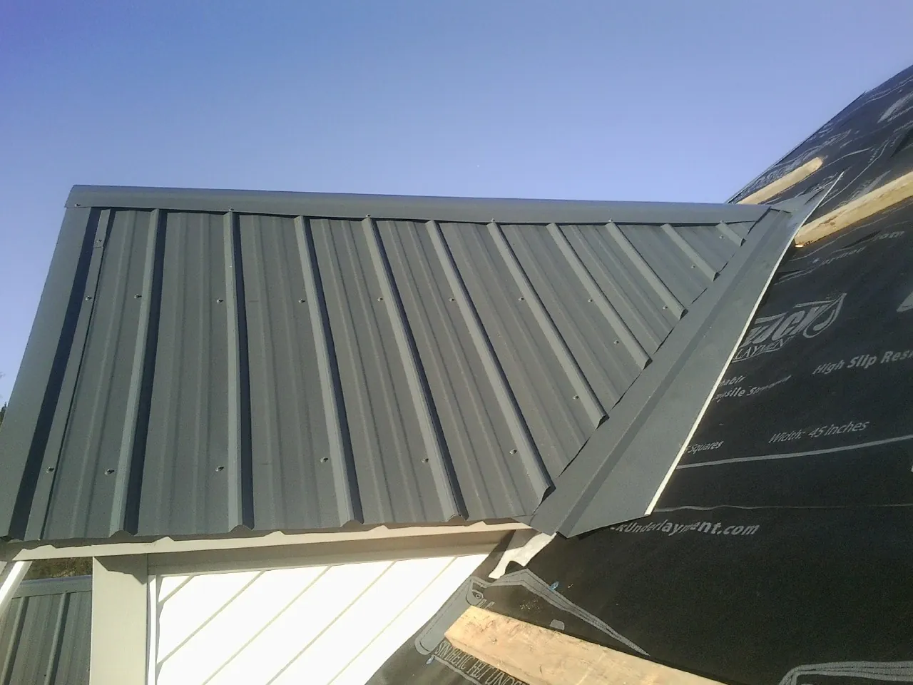 Gray metal roof panels going on over a garage gable in Warrenville