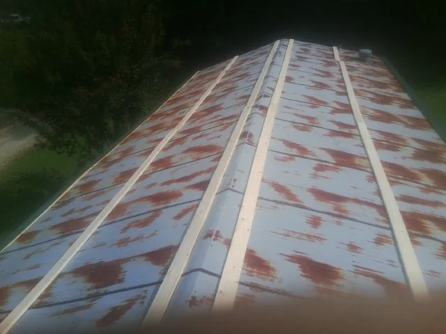 Rusted metal roof panels with new wood purlins before replacement — Storm Damage Roof Repair in Warrenville by Roofing Brothers