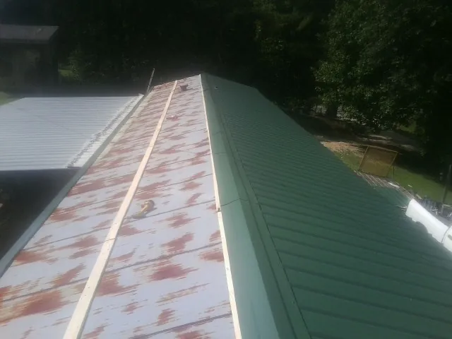Old rusted panels beside newly installed green metal roofing — Wind Damage Roof Repair by Roofing Brothers in Warrenville