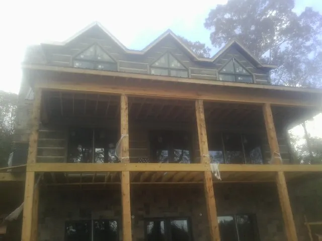 Dormers and porch framing on a large log home under construction — Roof Coating work by our crew in Warrenville